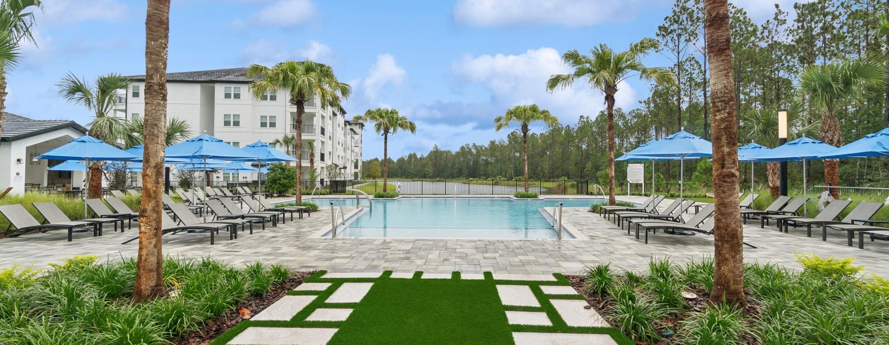 a pool with palm trees and a building in the background